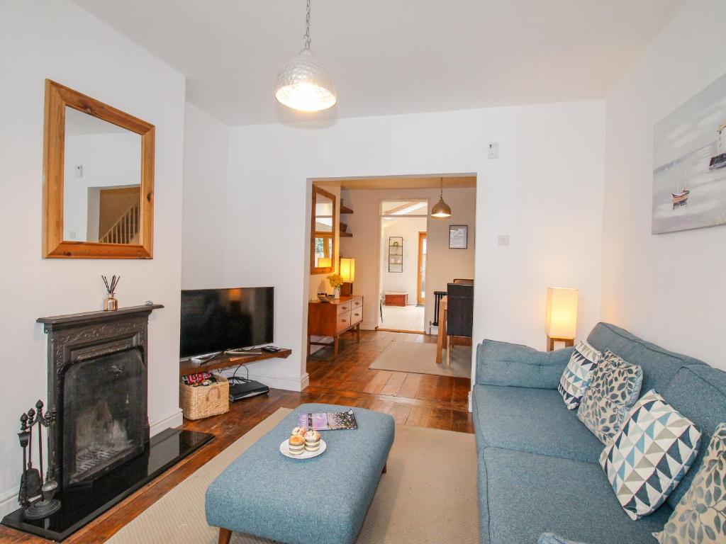 a living room with a blue couch and a fireplace at Owl's Rest in Weymouth
