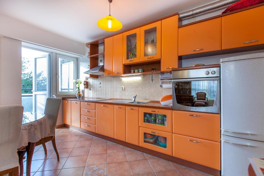 une grande cuisine avec des armoires orange et une table dans l'établissement Apartment Fabris, à Split