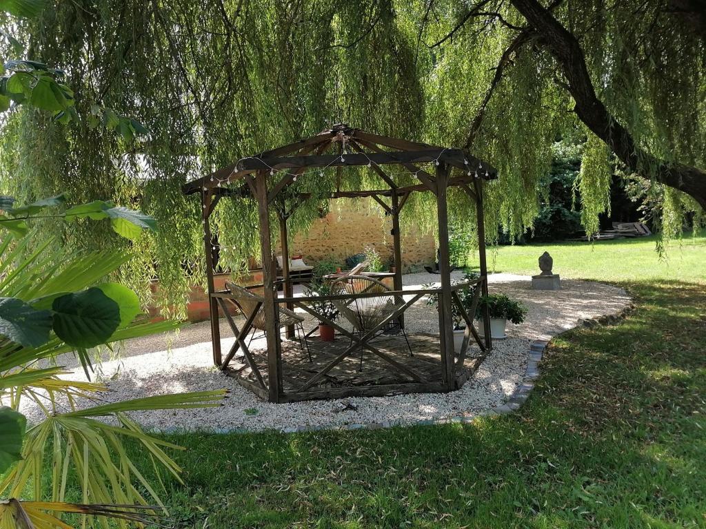 un cenador con una mesa de picnic en un parque en Sophie LE FEUVRE - Soins Energétiques, en Baugé