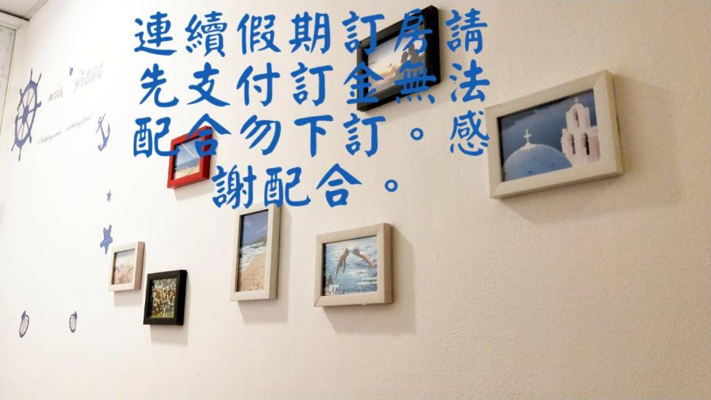 a wall with blue writing on a wall with pictures at Nandian Homestay in Eluan