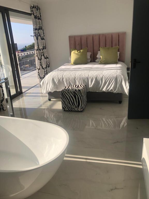 Un baño con cama y bañera en una habitación. en Sibani@ Dolphin coast, en Ballito