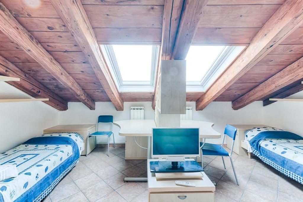 een kamer met 2 bedden en een tafel met een tv bij Trieste Loft Central Apartment in Trieste