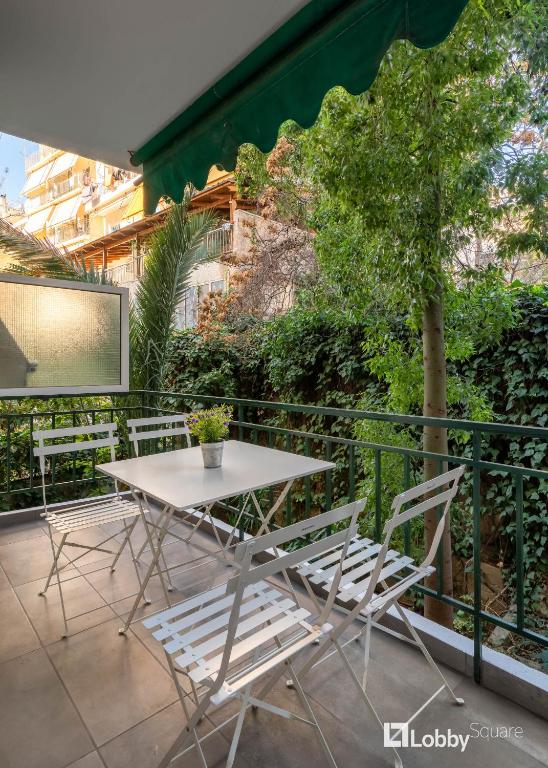 stół i krzesła na balkonie z ekranem w obiekcie Aether Apartment by LobbySquare w Atenach