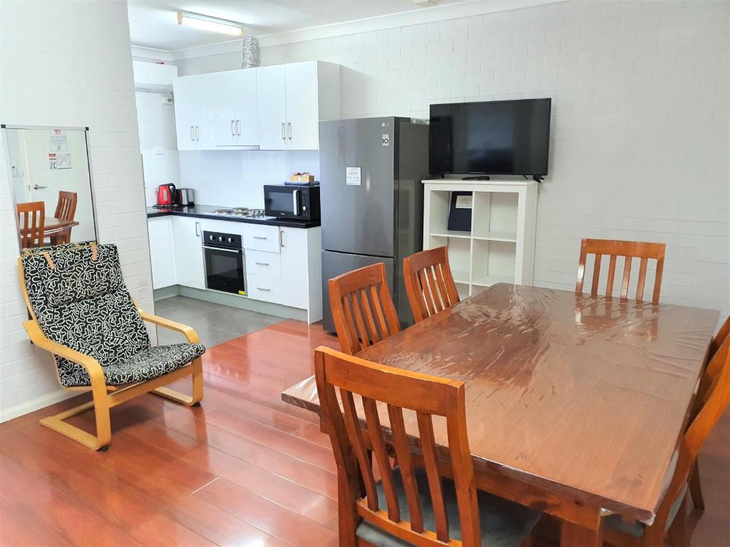 a kitchen with a wooden table and chairs and a dining room at Maria Motel in Moree