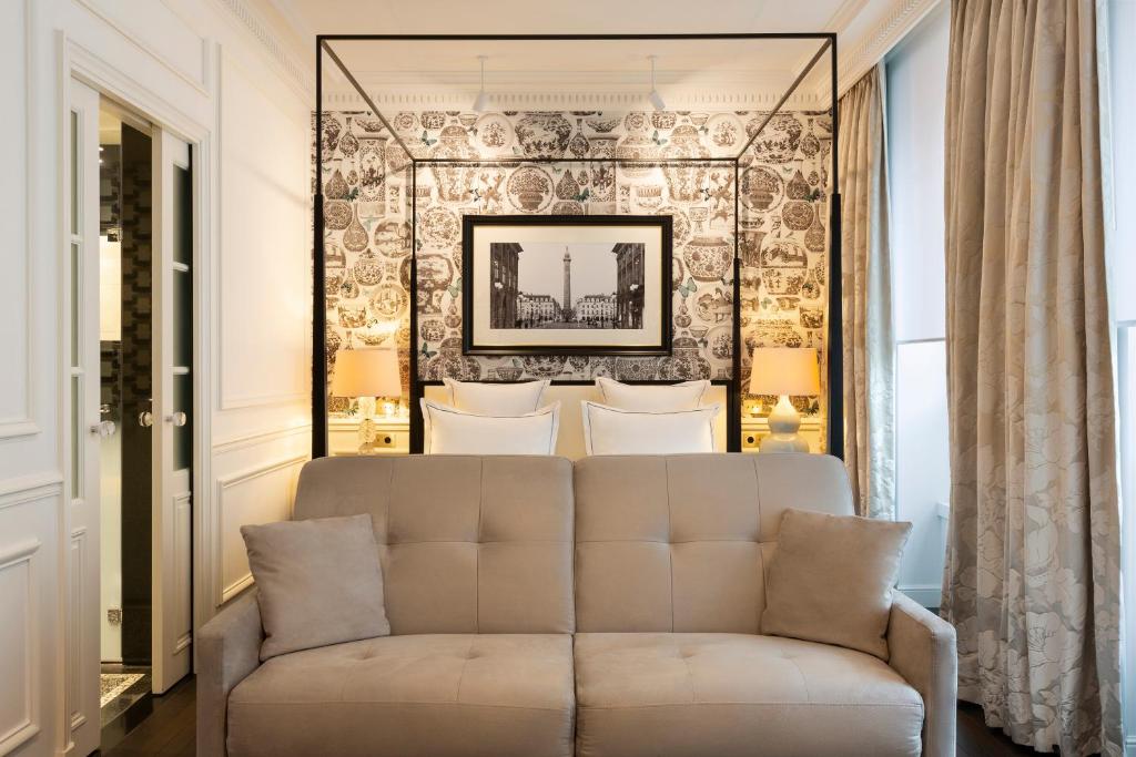 a living room with a couch in front of a wall at Hôtel Keppler in Paris