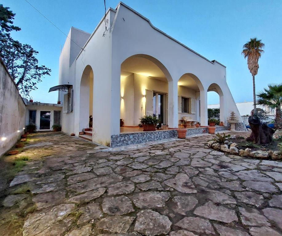 une église blanche avec une allée en pierre dans l'établissement Villa Musella B&B, à Porto Cesareo