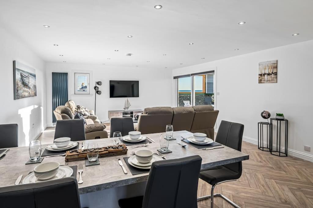 a dining room and living room with a table and chairs at Luxury Apartment with Sea Views in Arbroath