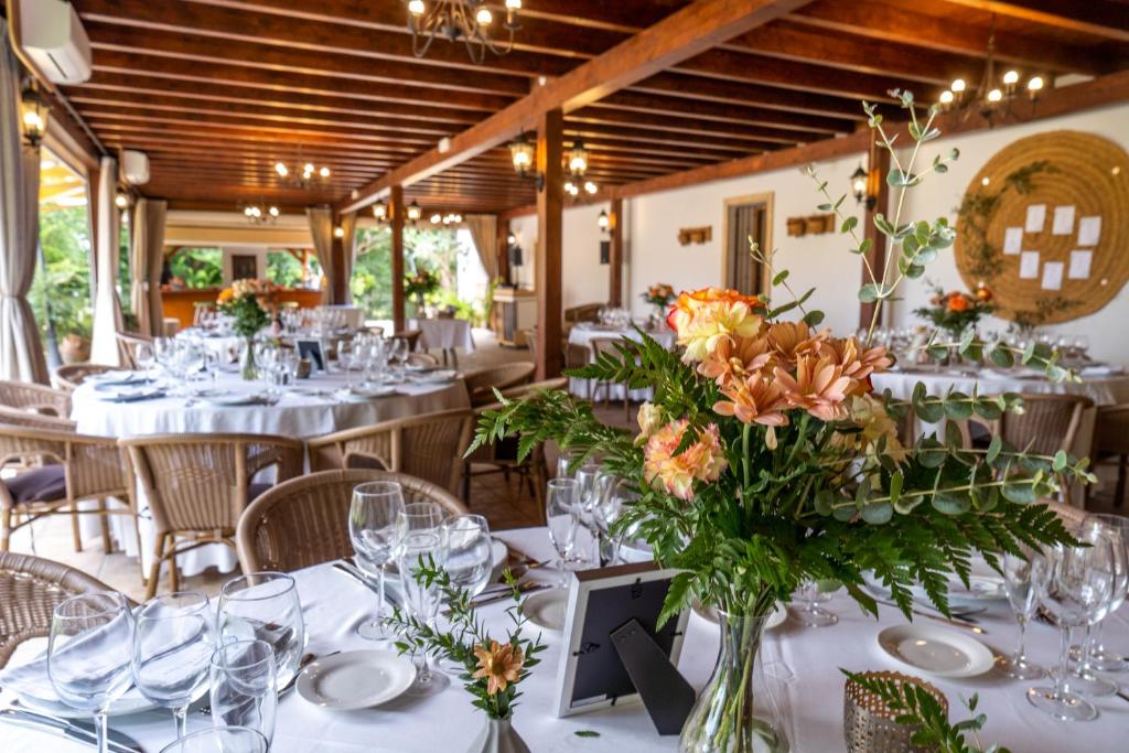 a dining room with white tables with flowers in a vase at Hotel Tossal d'Altea in Altea