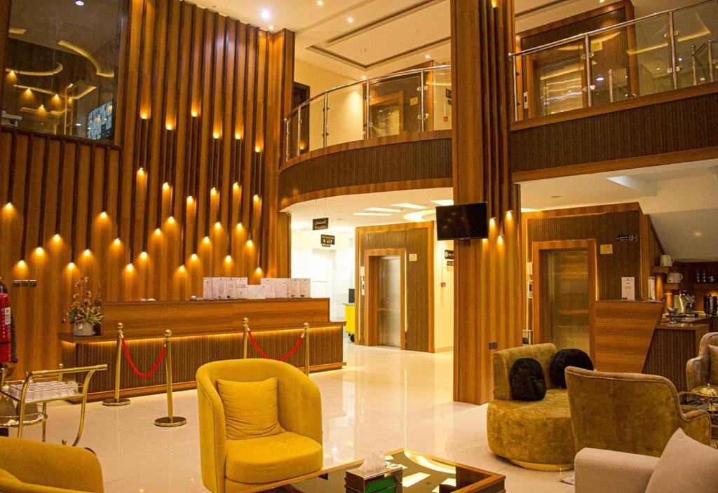 een lobby met gele stoelen en een bar bij ركن الروشن للشقق المخدومه in Hail