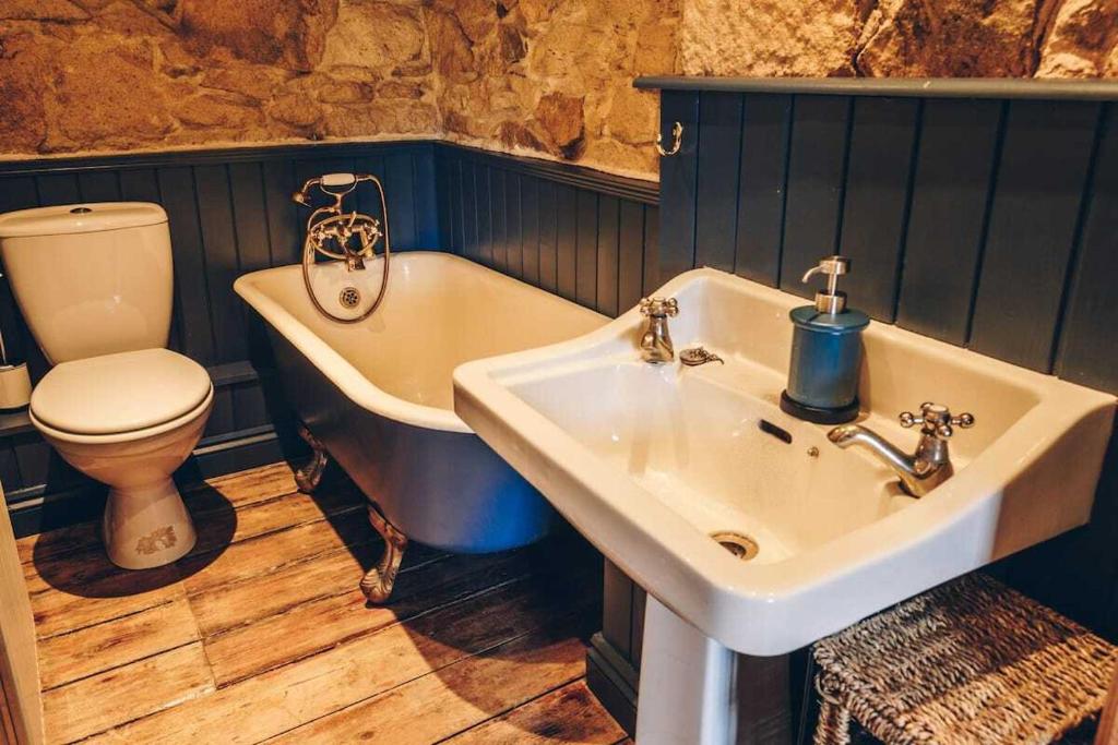 y baño con lavabo, bañera y aseo. en Lavender Cottage en Newquay