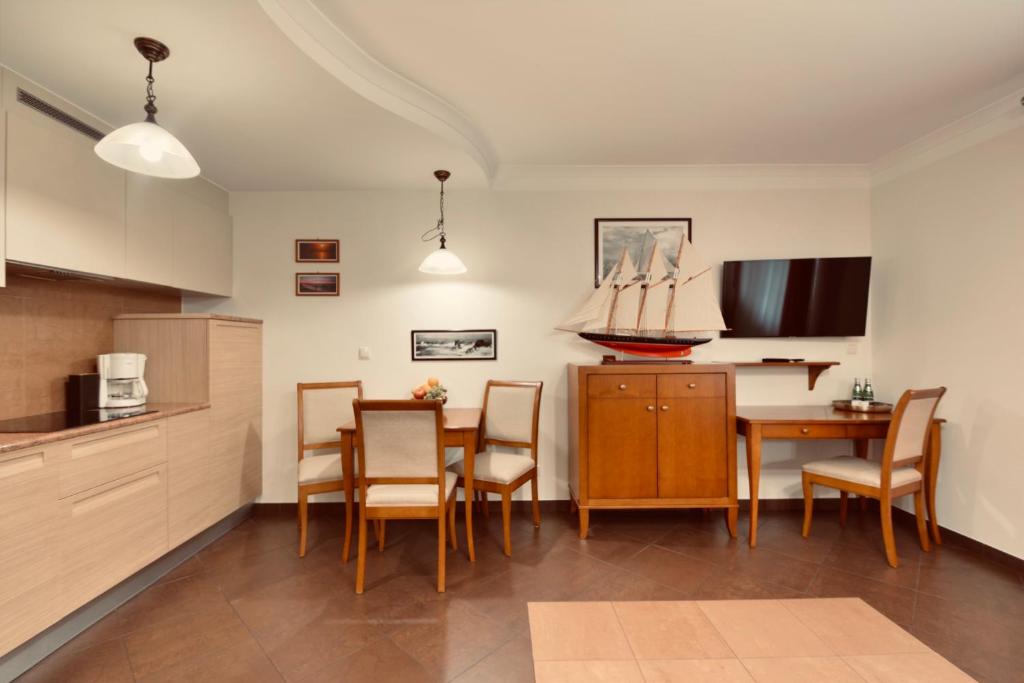 a kitchen and dining room with a table and chairs at NORTH Apartments Blue-Velvet, parking in Ustka