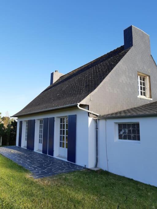 Biały dom z czarnym dachem w obiekcie Maison bord de mer w mieście Plouguerneau