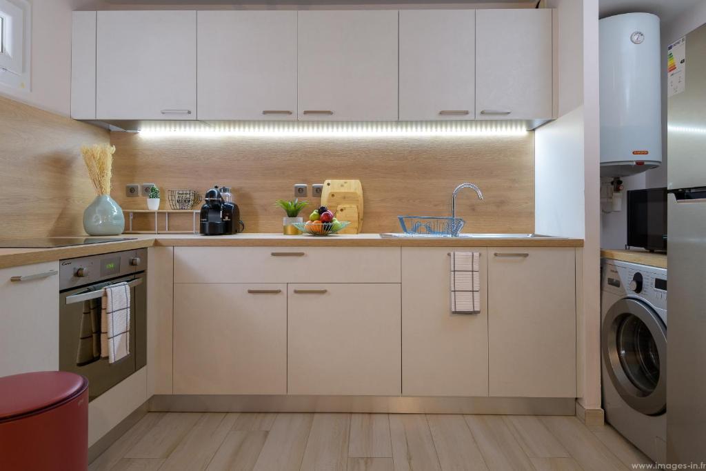 a kitchen with white cabinets and a dishwasher at City Cocoon T2 rénové proche centre Saint Denis in Saint-Denis