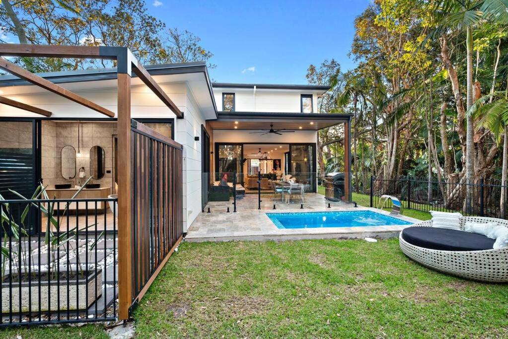 a house with a swimming pool in a yard at Retreat at Byron in Byron Bay