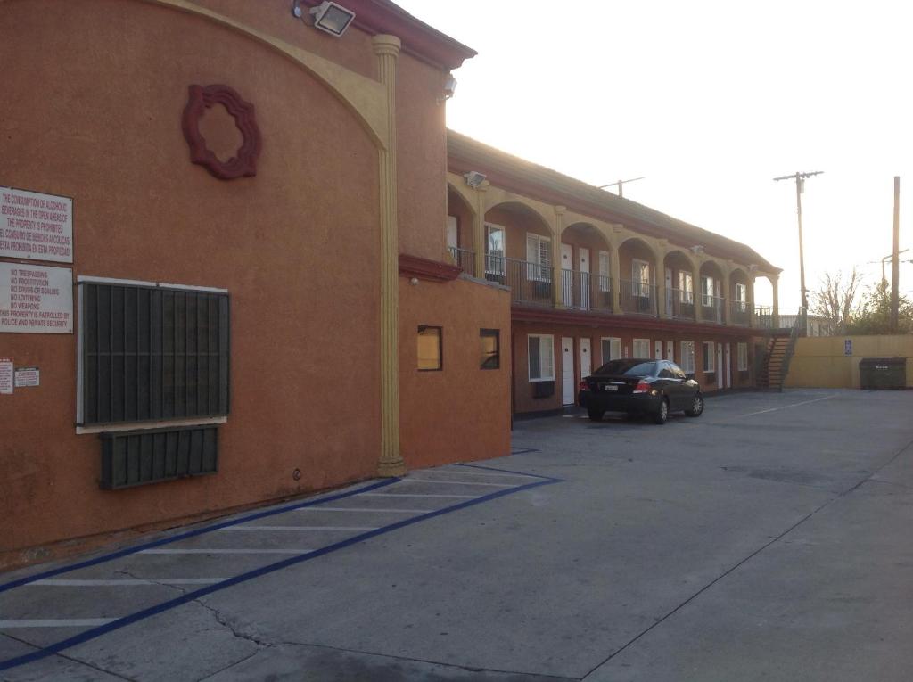 a building with a car parked in a parking lot at Bronco Motel South Central in Los Angeles
