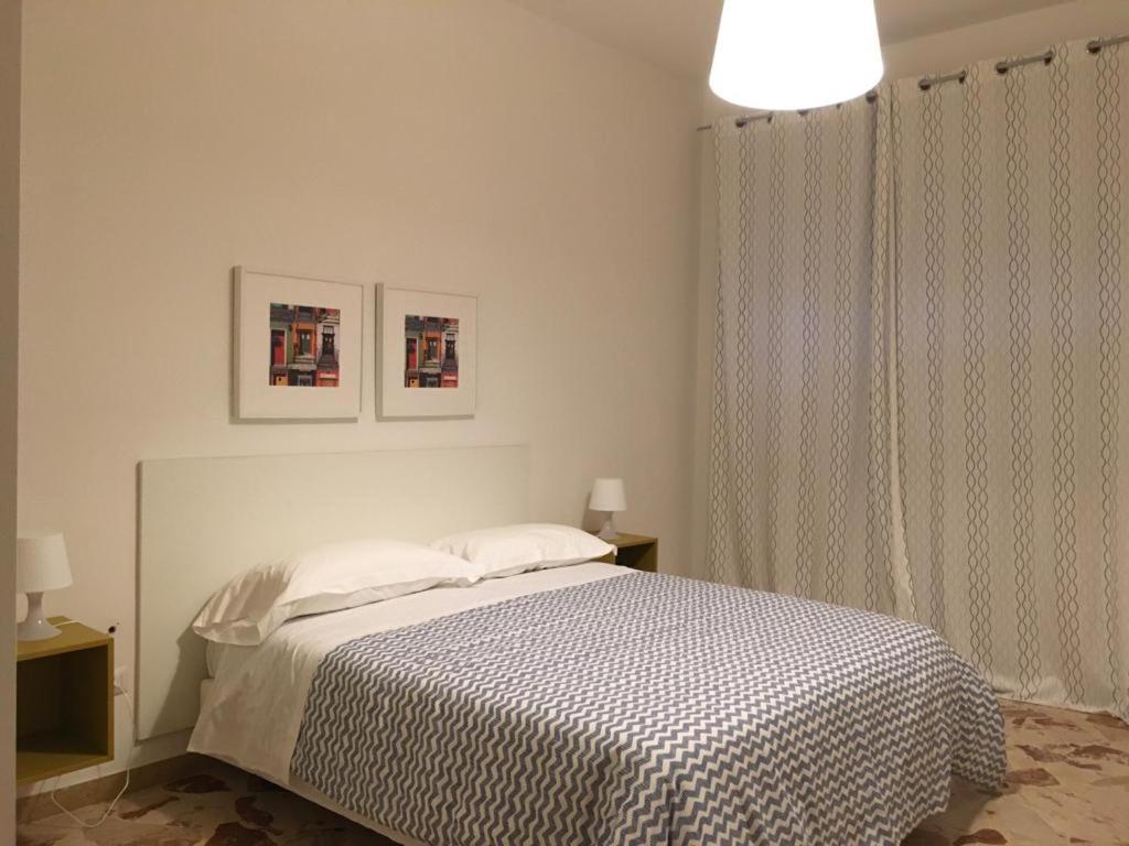 Una habitación blanca con una cama y una ventana en Tizi Apartments, en Maiori