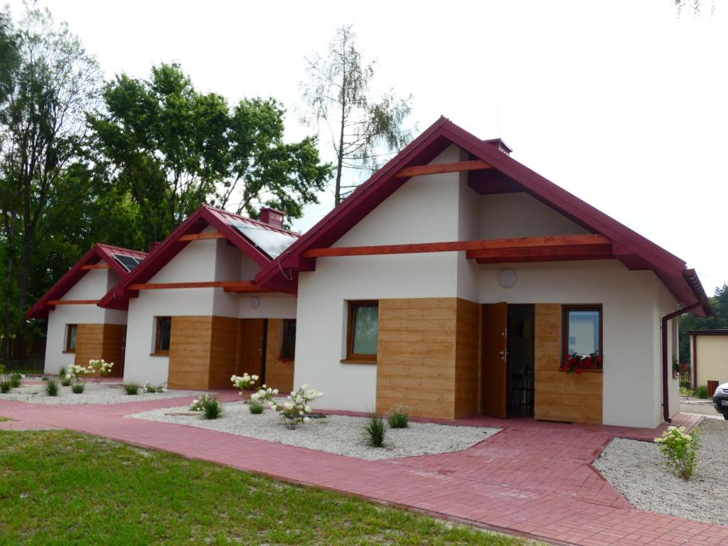 a house with a red roof at Miejsko Gminny Ośrodek Sportu i Rekreacji in Łopuszno