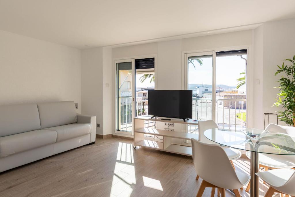 a living room with a couch and a table with a tv at Loft Los Caracoles in Palamós