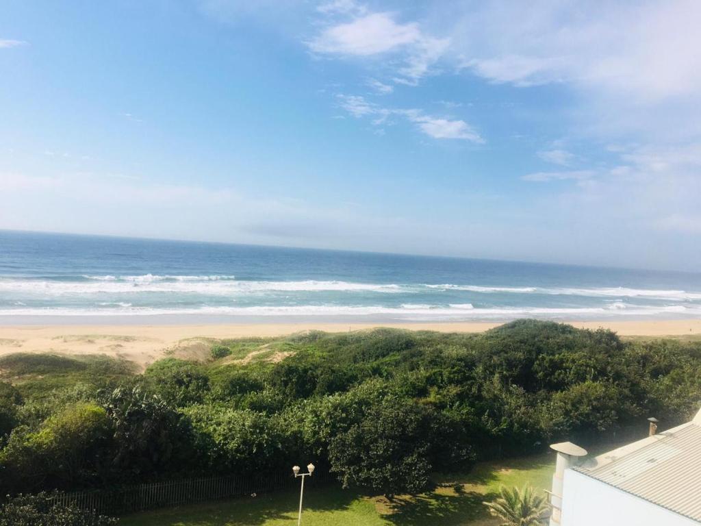 a view of the beach from the balcony of a house at Amanzimtoti Afsaal Holiday Letting in Amanzimtoti