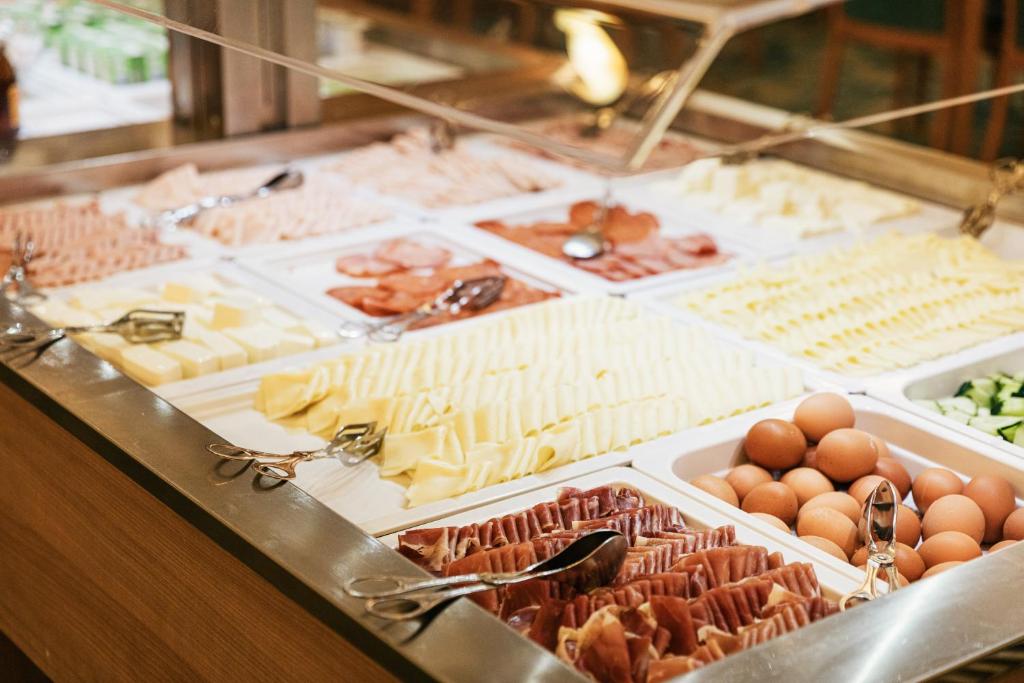 A chilled buffet displays cheeses, sliced meats, eggs and vegetables.