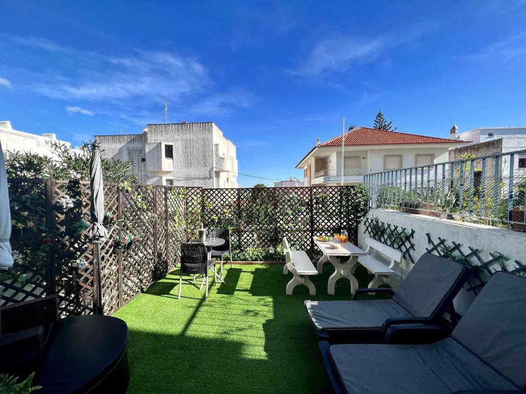 a patio with chairs and a table and a fence at Albufeira Stylish by Homing in Albufeira