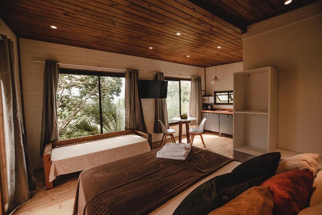 a bedroom with a bed and a window in a room at Pousada Colina Verde in Garopaba