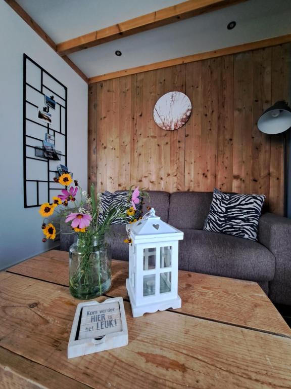 a living room with a couch and a table with flowers at Vakantiewoning 't Molenhuisje Westkapelle in Westkapelle