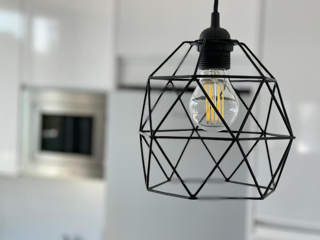a black light fixture hanging from a wall at LHOME CÁDIZ in Cádiz