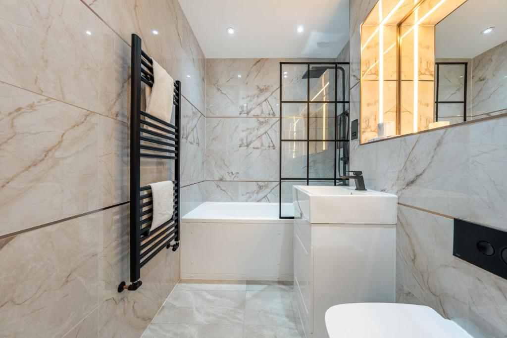 La salle de bains est pourvue d'une baignoire, de toilettes et d'un lavabo. dans l'établissement Brand New London Luxury House - Sleeps 8, à Londres