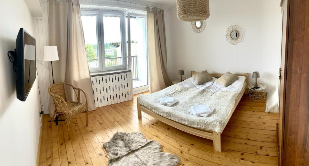 a bedroom with a bed and a dog laying on the floor at Apartament Na Skarpie in Nowy Targ