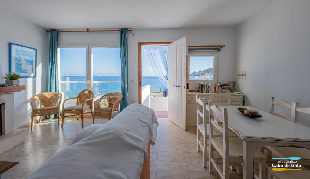 a bedroom with a bed and a kitchen with the ocean at Calilla de San José in San José