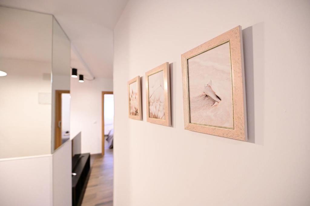 a hallway with four pictures on a wall at 4 Mares Apartamentos M in Loredo