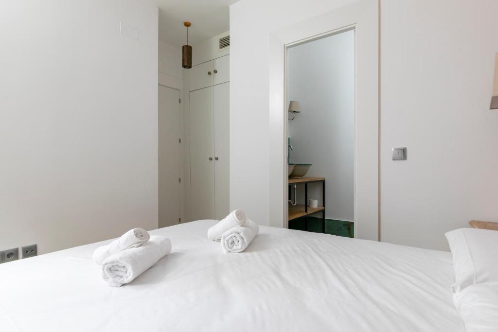 a white bed with towels on top of it at HOMEABOUT RÍOS ROSAS APARTMENT in Madrid