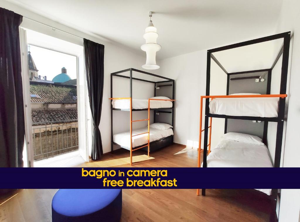 拿坡里的住宿－Tric Trac Hostel，一间卧室设有两张双层床和一扇窗户。