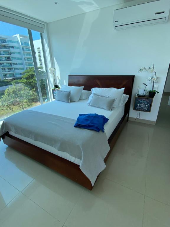 a bedroom with a large bed with a large window at Playa Boquilla - Boquilla Beach - Apto con servicios de Hotel Sonesta in Cartagena de Indias