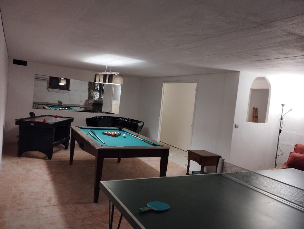 una sala de estar con 2 mesas de ping pong. en Maison du Chesnoy, en Briare