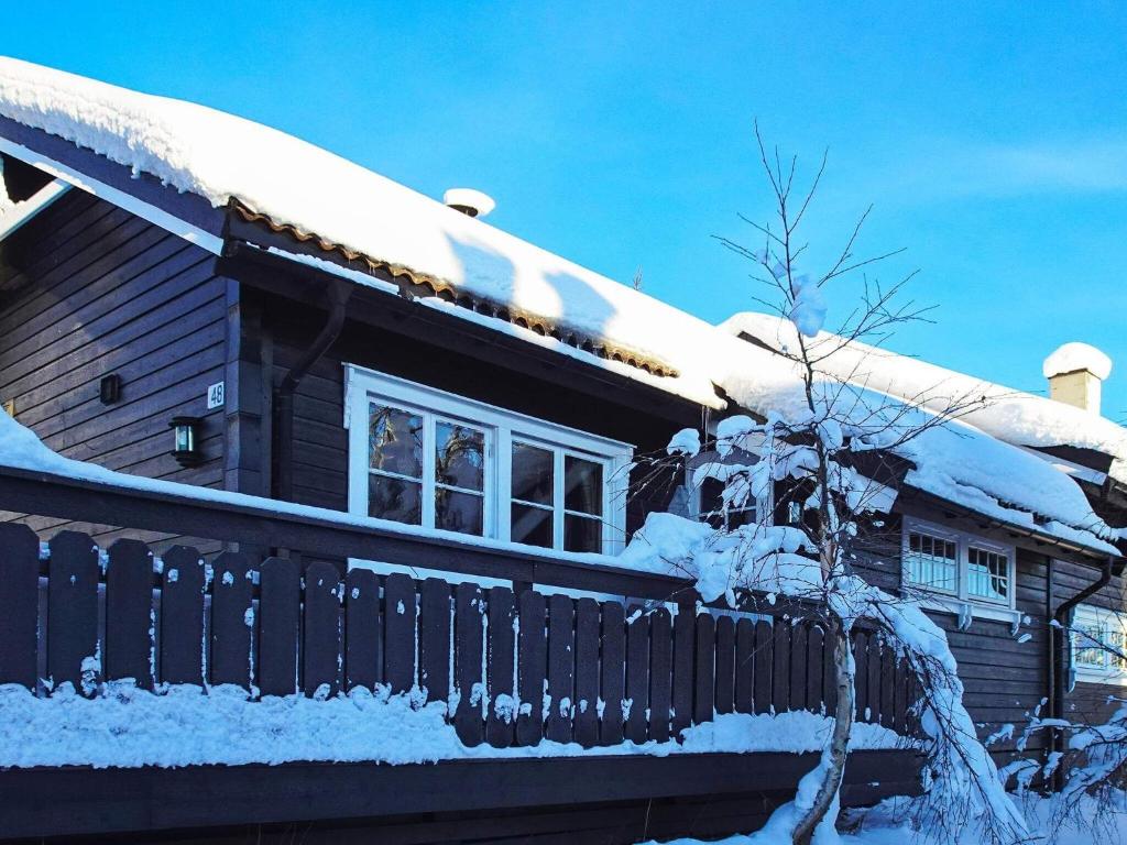 a house covered in snow with a fence at Holiday home Svingvoll III in Svingvoll