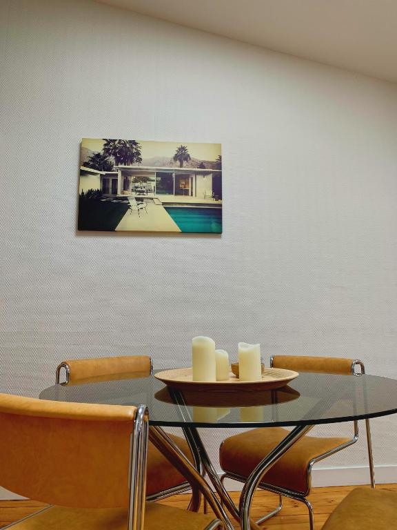 une table à manger et des chaises avec une photo sur le mur dans l'établissement Hotel de Ville 3 et Parking, à La Rochelle