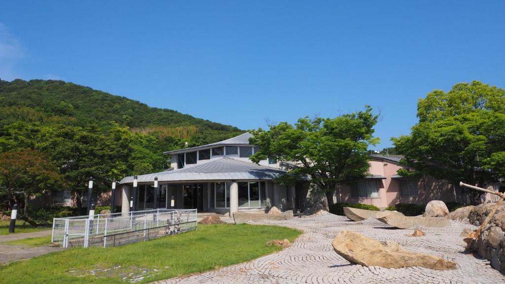 uma casa grande com uma cerca em frente em Le Port Awashima em Mitoyo