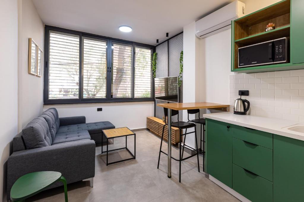 a living room with a couch and a kitchen at Boutique Central old town Apartment in Beer Sheva