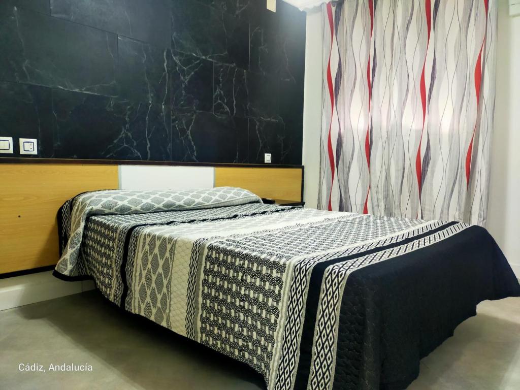 una camera da letto con un letto coperto di Hostal la Campana a La Línea de la Concepción