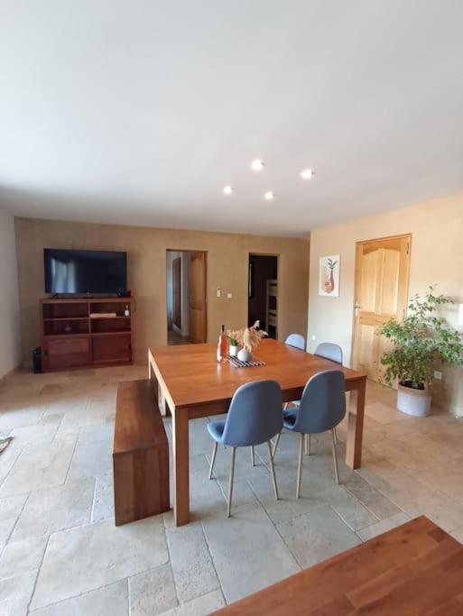 a dining room with a wooden table and chairs at Gite Himaya - Vaison la Romaine in Vaison-la-Romaine