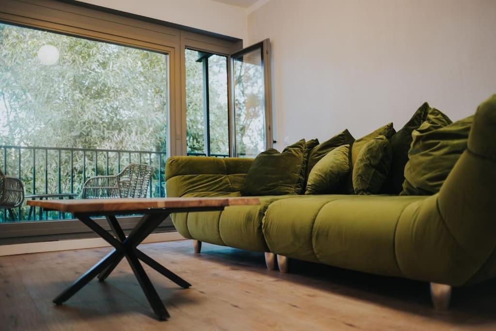 sala de estar con sofá verde y mesa en Fabrica Apartments 22, en Cluj-Napoca