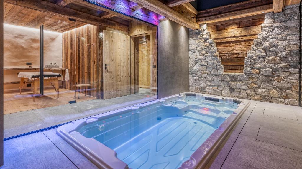 a swimming pool in a room with a stone wall at Akchalet Akon in Livigno