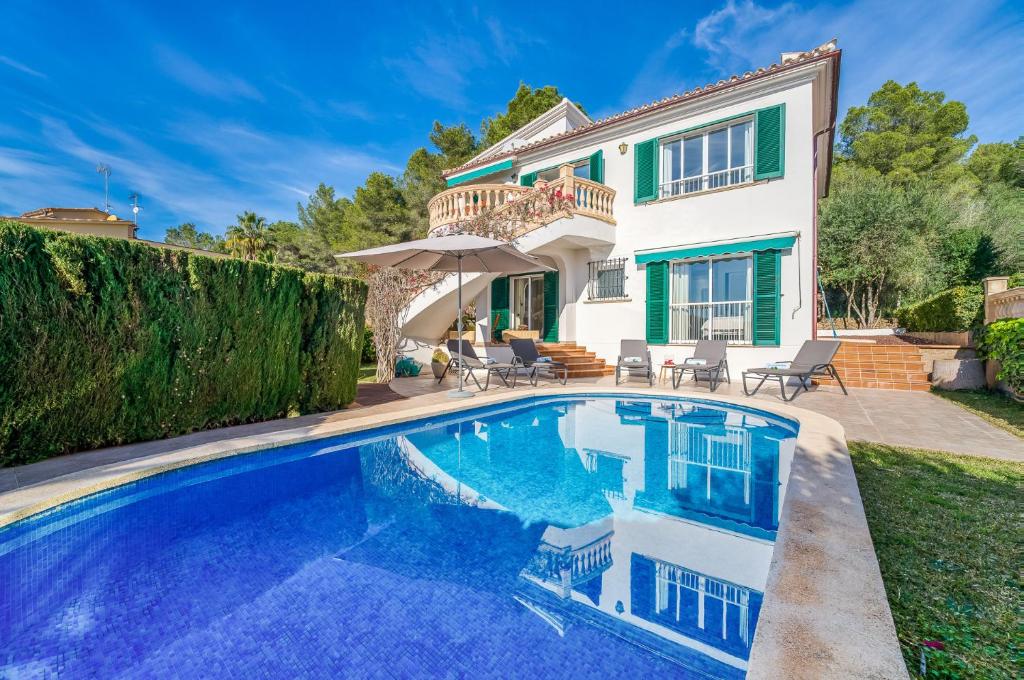 uma villa com piscina em frente a uma casa em Ideal Property Mallorca - Casa Osborne em Port d'Alcudia