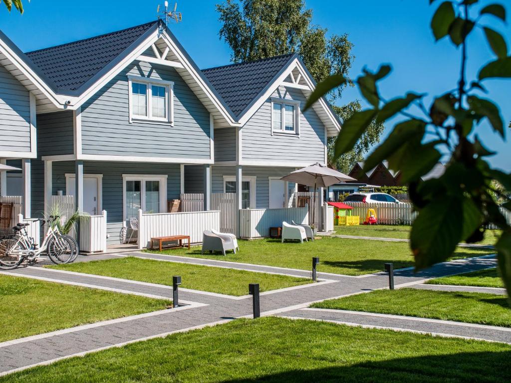 una casa gris con un patio con una casa en Holiday Bay, en Władysławowo