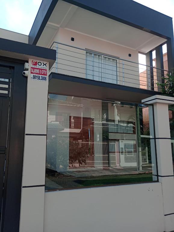 a building with a sign in front of it at Casa para Veraneio em Torres in Torres