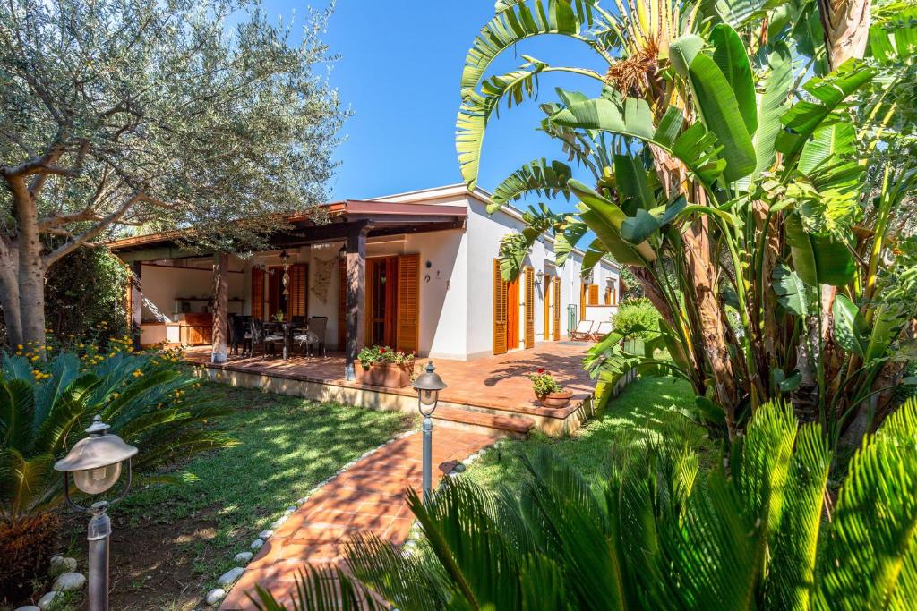 a house with a garden with palm trees at Villetta Cala Rossa in Terrasini