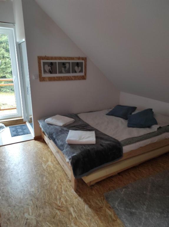 1 dormitorio con 1 cama en una habitación con ventana en Gościniec Śliwkula en Jaworzynka