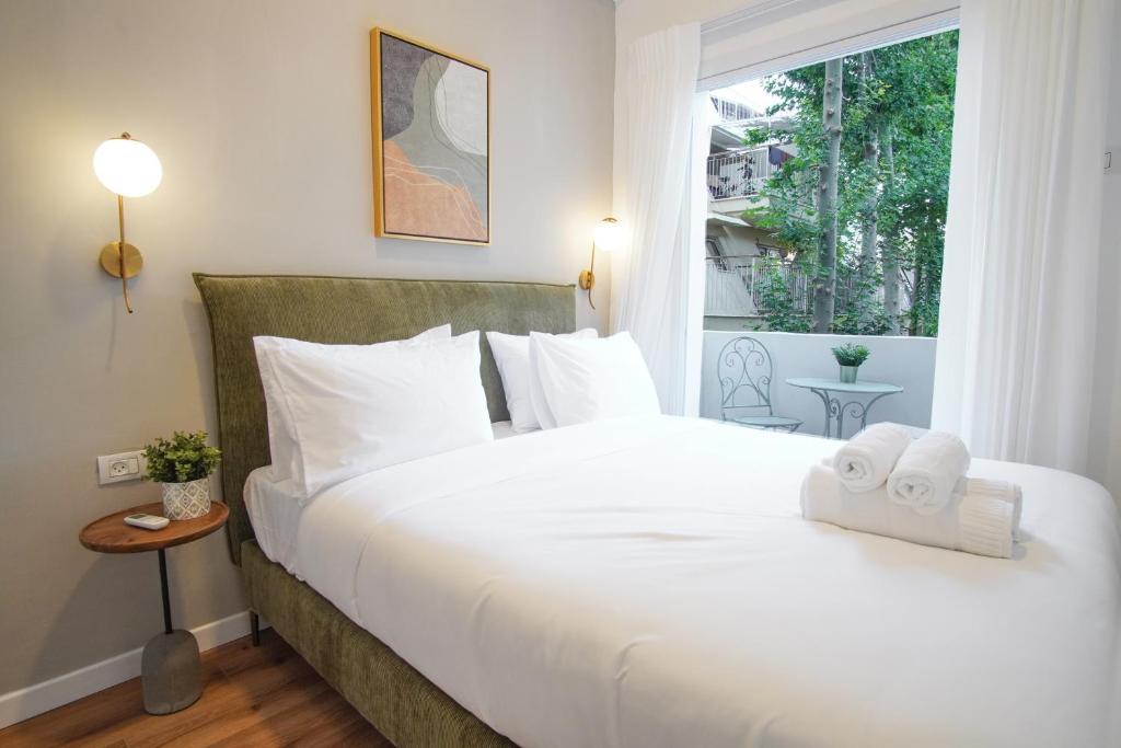una camera da letto con un grande letto bianco con asciugamani di Bruno 55 By Peraia a Tel Aviv
